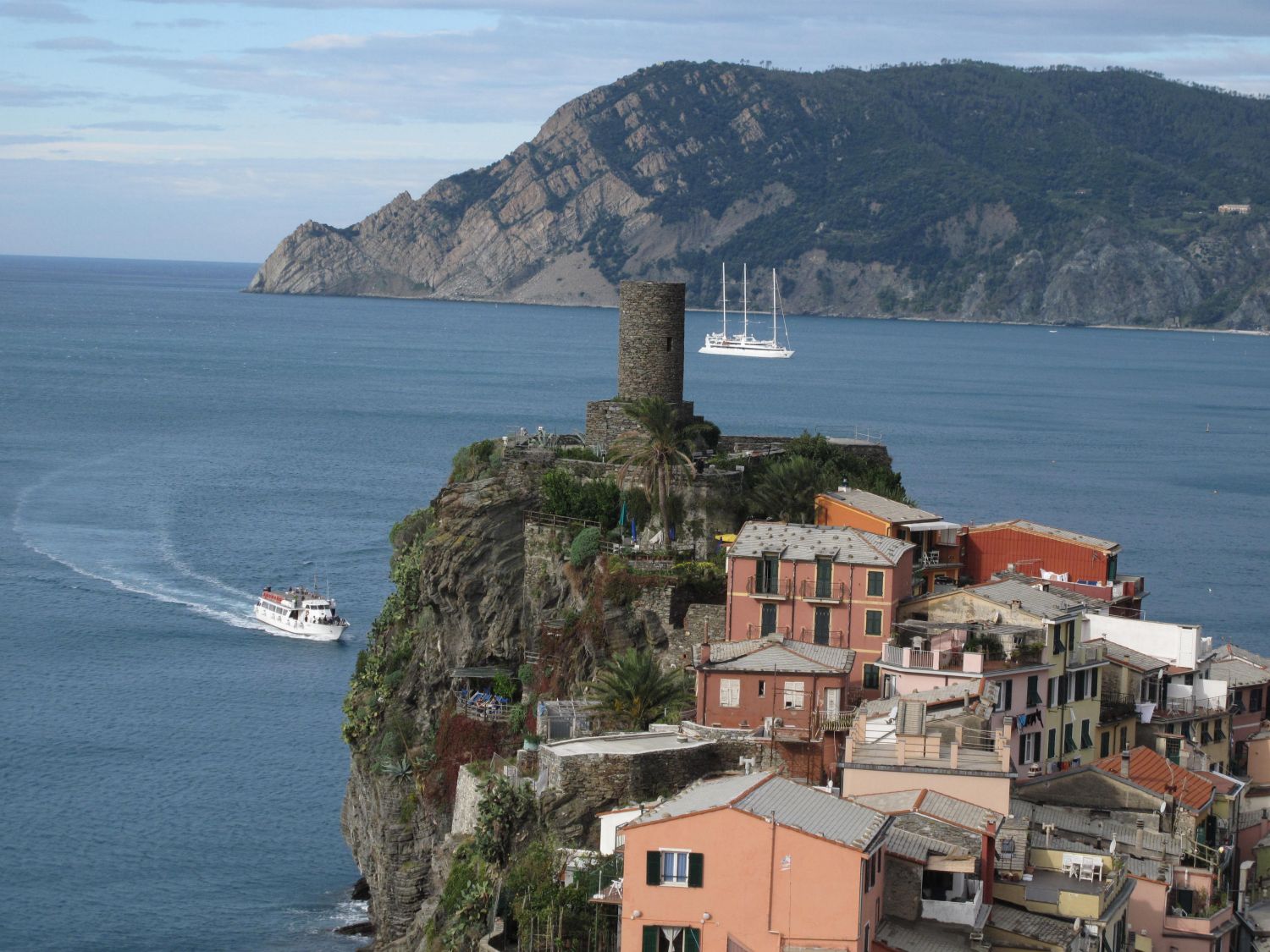 Vi flyver til Milano og tager toget til Vernazza. Vi har lejet et værelse i den rosa bygningen lige under tårnet.