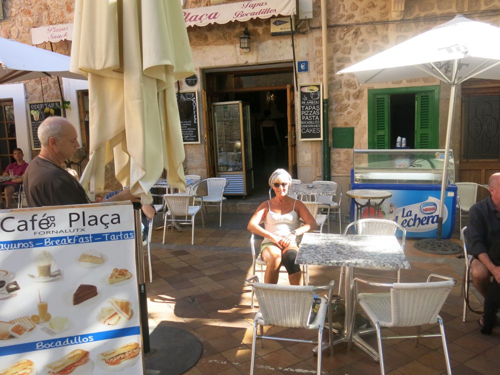 Fruen nyder en café con lecce på torvet i Fornalutx